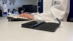 Sairaanhoitajan kädet näppäimistöllä ja ajanvarauspuhelin pöydällä