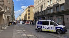 Poliisi valvoo onnettomuuspaikkaa Fredrikinkadulla, missä sattui kaasuräjähdys. Kuvassa poliisin auto autotiellä tapahtumapaikan vieressä.