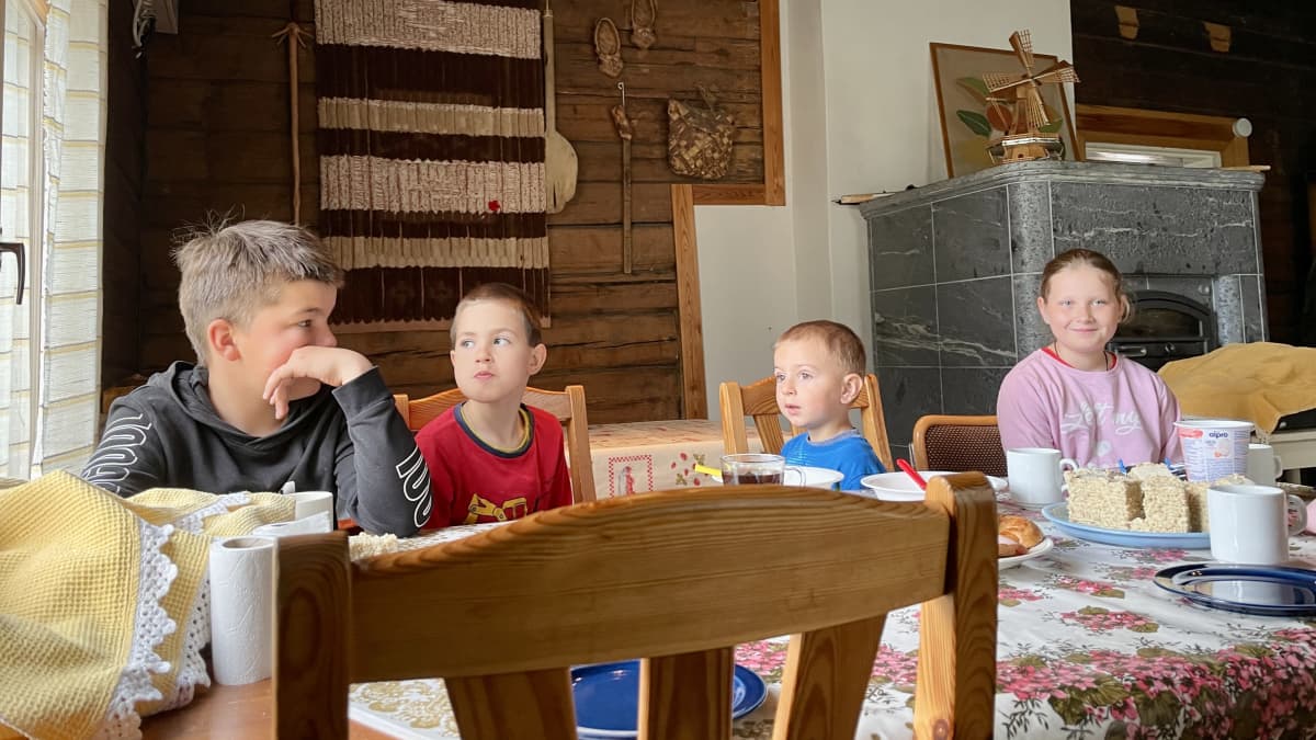 Ukrainalaisia lapsia aamiaispöydän ääressä.
