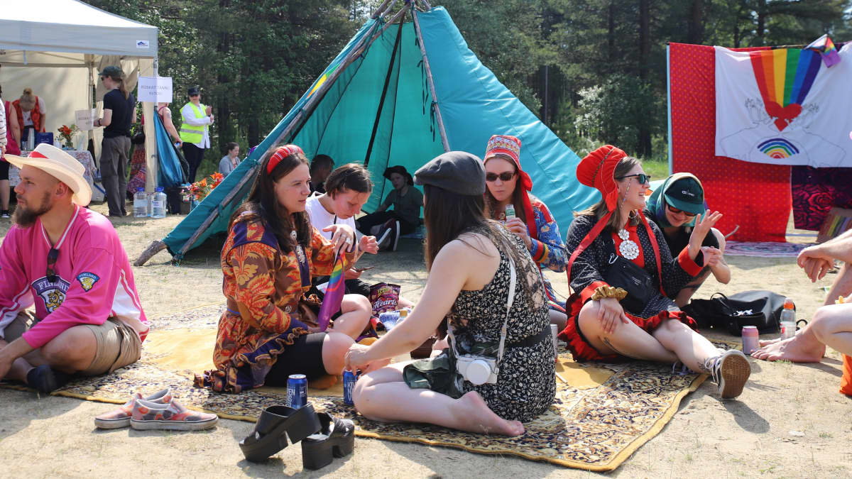 Inari Pride. Ihmiset istuvat piknik viltin päällä.