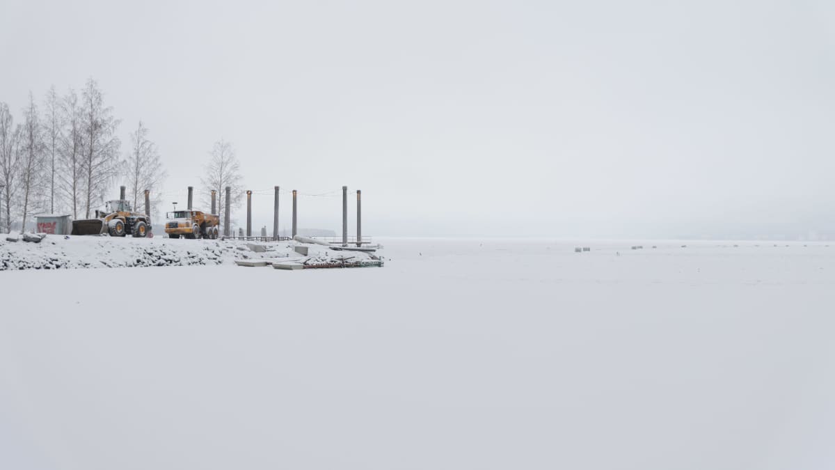 Tampereelle rakennettavan tekosaaren ponttooneja ja työkoneita talvella.