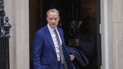 Dominic Raab astuu ovesta ulos takki kädessään.