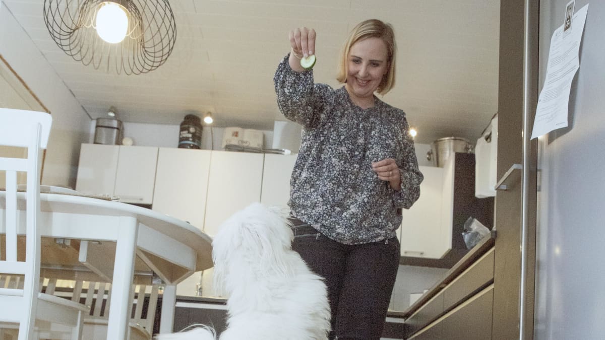 Laura Viiliäinen leikkii Poju-koiransa kanssa.