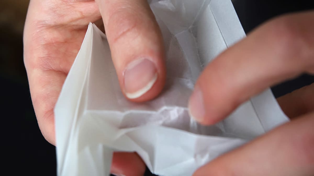 Juho Könkkölän käsissä kuviolle taiteltua origamipaperia.