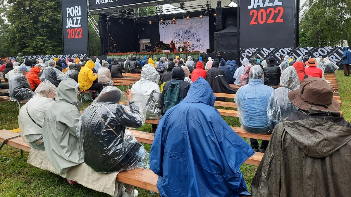 Yleisöä sadetakeissa Porin jazzfestivaalien katsomossa.