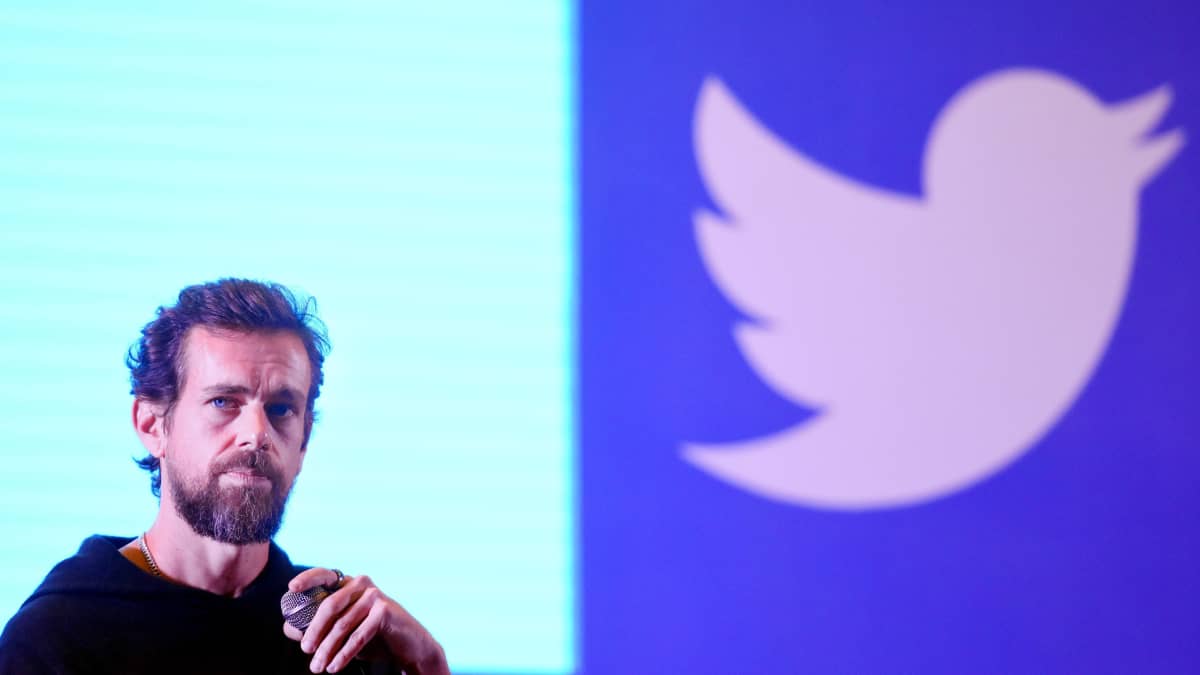 Jack Dorsey taustallaan Twitterin logo