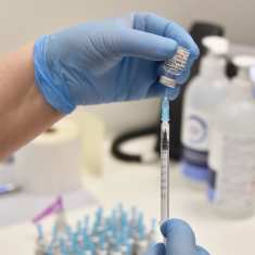 Spruta fylls med vaccin från en liten dosa. 