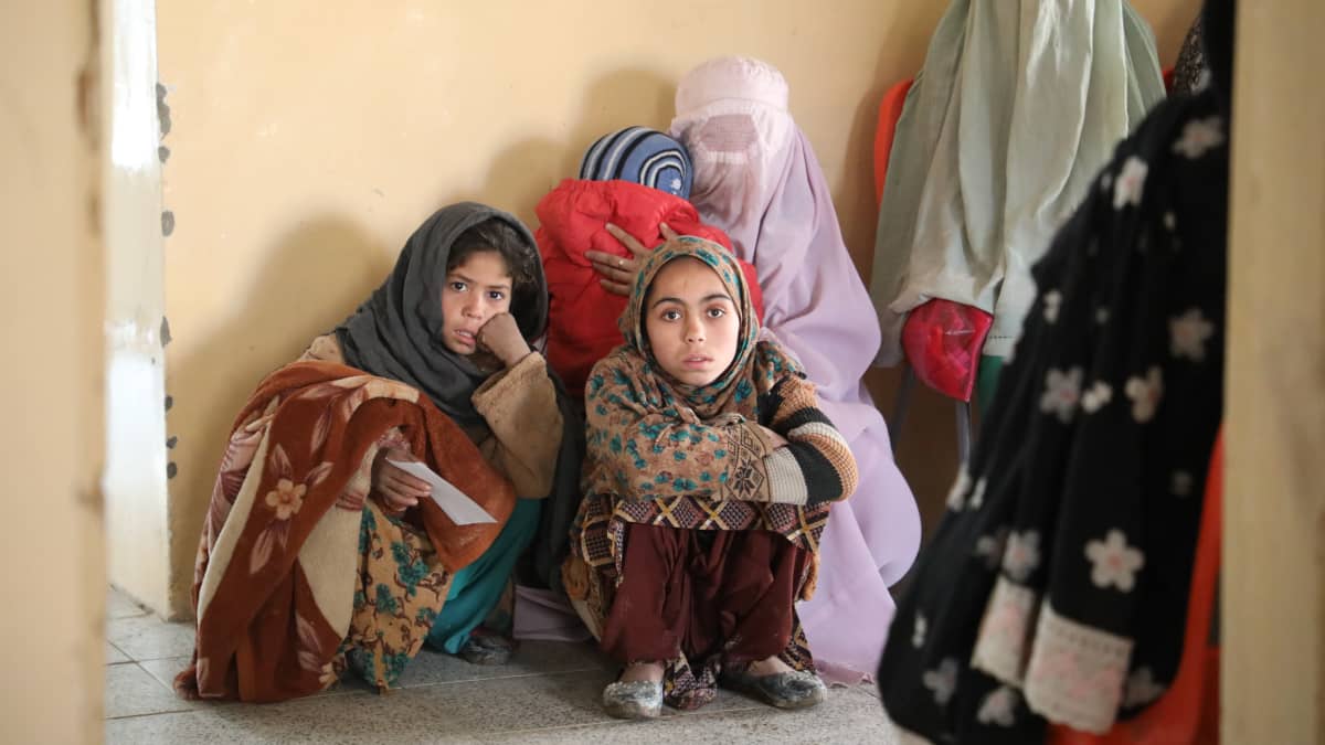 Äiti lapsineen odottaa vuoroaan terveysasemalla Etelä-Afganistanissa.
