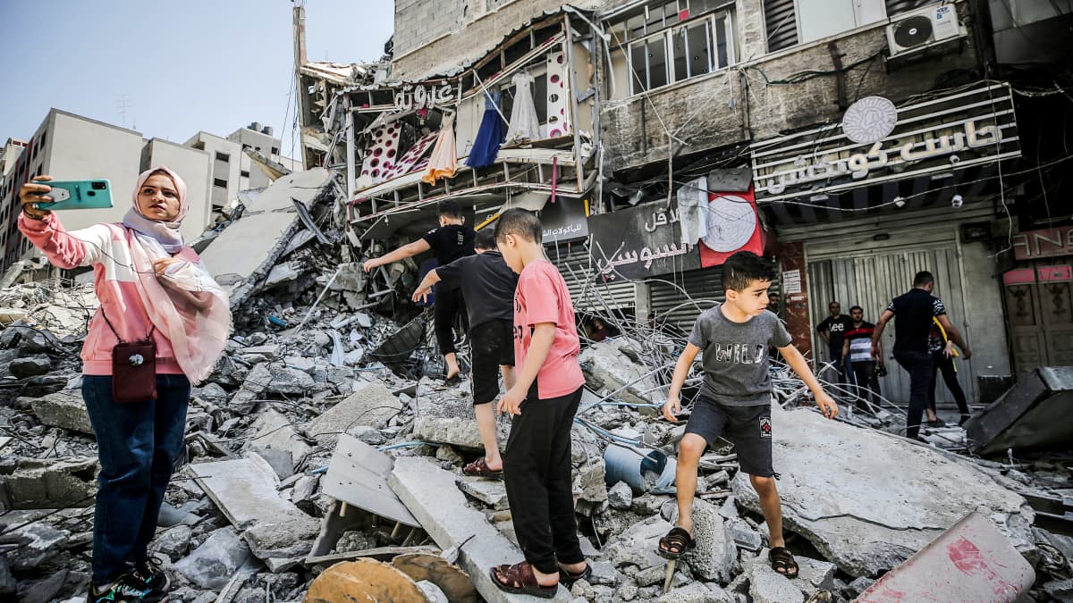Palestiinalaisia tarkastelemassa tuhottuja taloja.