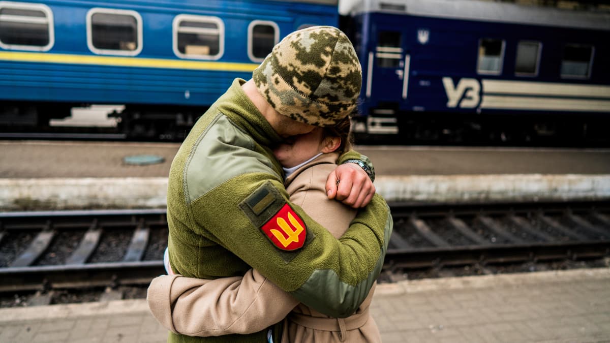 Sotilas ja nainen halaavat juna-asemalla Lvivissä.