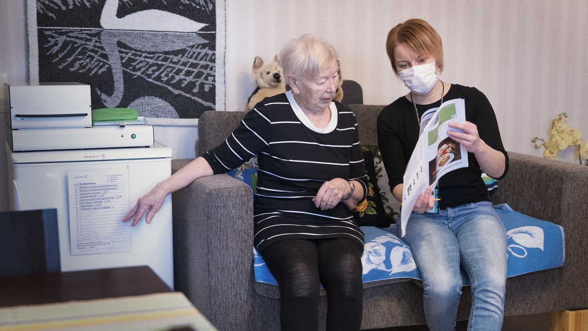 Kerttu Valkonen ja Jenniina Sirkka lukevat ruoka-automaatin ruokalistaa.