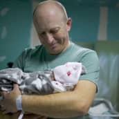 Isä pitelee vauvaansa kiovalaisessa synnytyssairaalassa 3.3.2022.