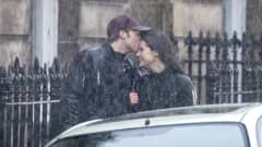 Williamia näyttelevä Ed McVey suutelee Catherinea näyttelevää Meg Bellamya kadulla vesisateessa.