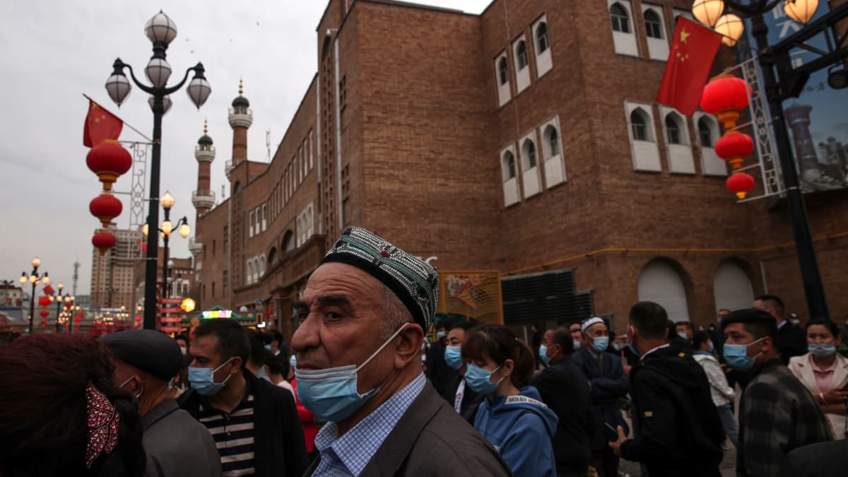 Uiguuri mies seisoo väkijoukossa Xinjiangissa, Kiinassa.