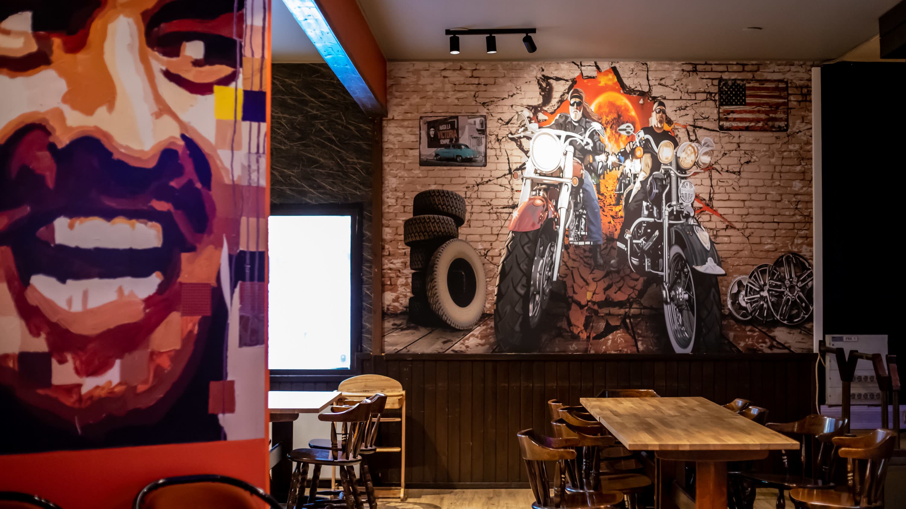 Ravintolan seinällä on iso seinämaalaus moottoripyöristä.