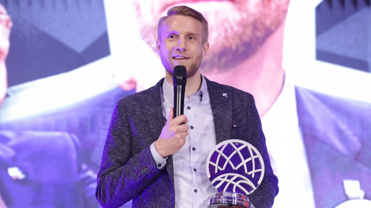Tuomas Iisalo poseeraa Mestarien liigan vuoden valmentaja -palkinnon kanssa.
