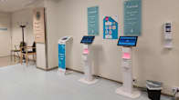 Ilmoittautumisautomaatteja sairaalan käytävällä.