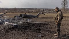 Ukrainalainen sotilas katselee alas ammutun venäläisen helikopterin romua. 