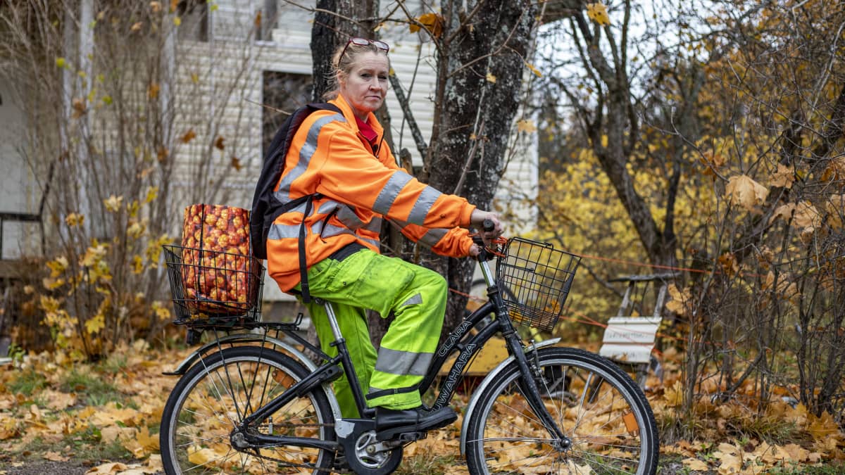Nainen ajaa polkupyörällä ruskaisessa maisemassa