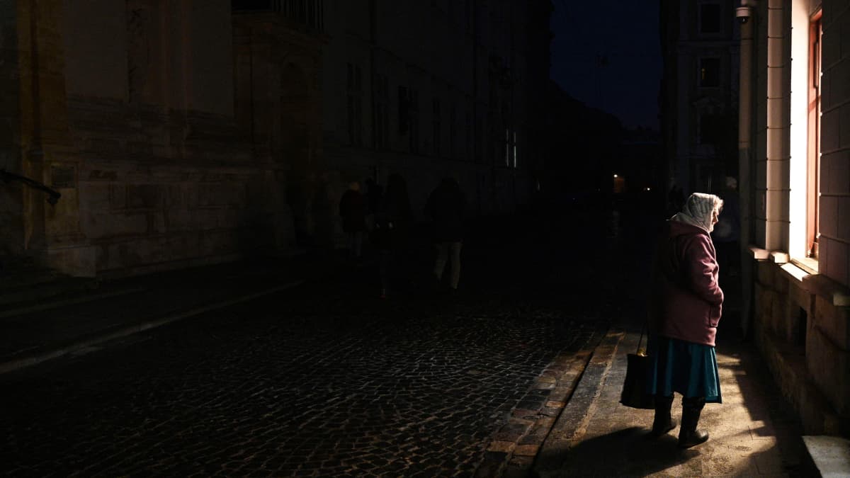 Nainen kävelee pimeällä kadulla Lvivissä.