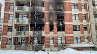 Brick apartment building partially covered in black soot from a fire.