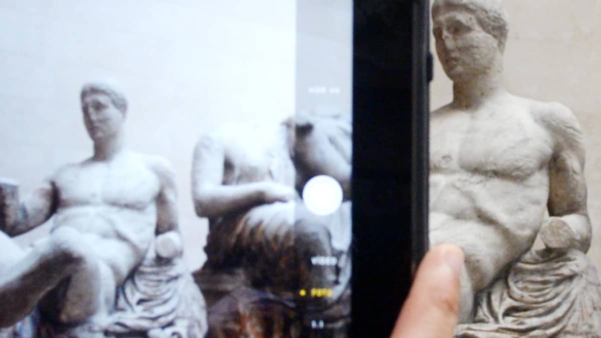 Ihminen ottaa kuvaa Parthenonin marmoriveistoksesta British Museumissa. 
