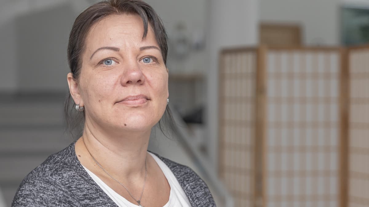 Nainen katsoo kameraan.