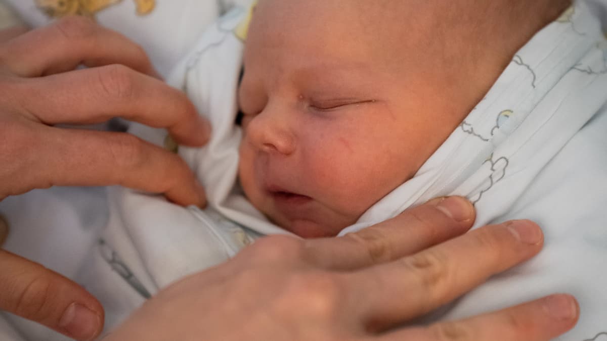 Vastasyntynyt poikavauva nukkuu peittojen sisällä sairaalassa.