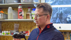 Mies pitää varastossa golfmailaa kädessään.