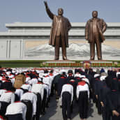 Vuonna 2016 julkaistussa kuvassa koululapset osoittavat kunnioitusta maan aikaisempien johtajiien kunniaksi pystytetyille näköispatsaille  Pjongjangissa.