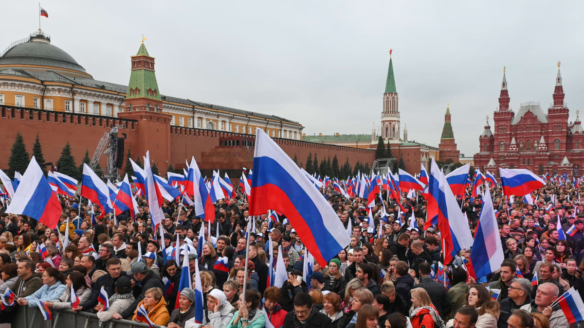 Venäläiset kokoontuvat juhlimaan seremonian jälkeen, jossa allekirjoitettiin sopimuksia uusien alueiden liittämisestä Venäjään Punaiselle torille Moskovassa 30.9.2022.