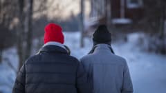Nainen ja mies kävelevät käsikynkkään talvipakkasella.