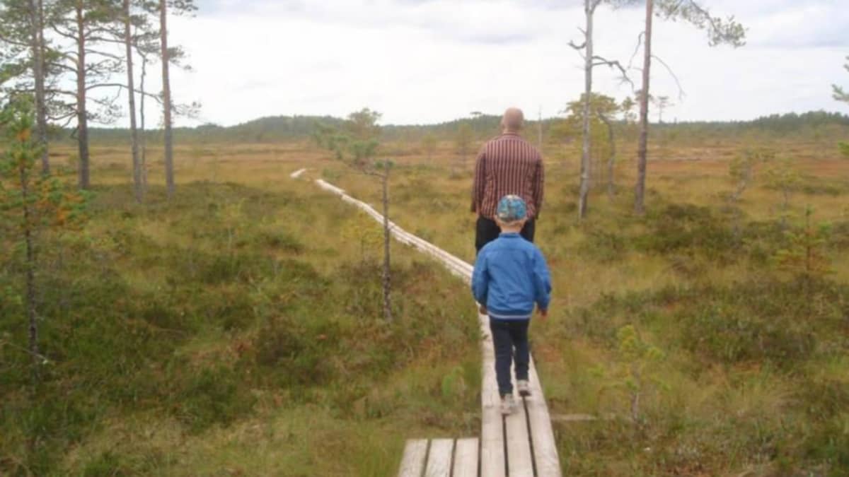 Kai Mattila kävelee poikansa kanssa pitkospuita pitkin.