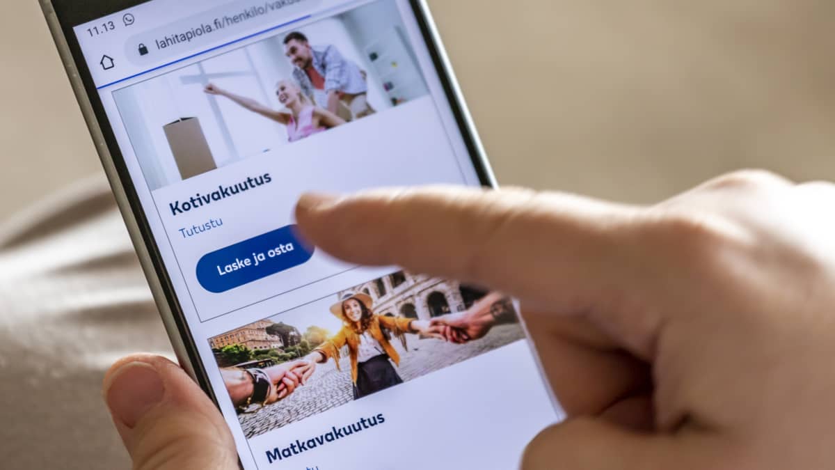 Henkilö selaa matkapuhelimella vakuutusyhtiön nettisivuja.