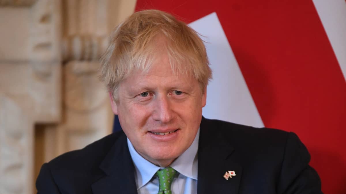 Boris Johnson taustallaan Britannian lippu.
