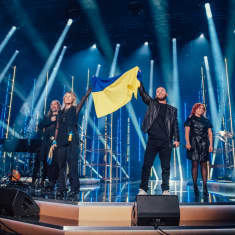 Elämäni Biisin tähtiartistit seisovat lavalla Ukrainan lipun kanssa. 