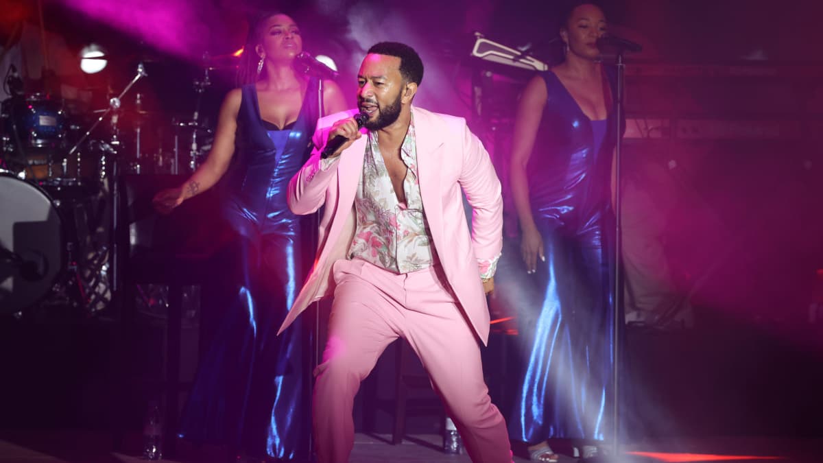 John Legend esiintymässä vaaleanpunaisessa asussa.