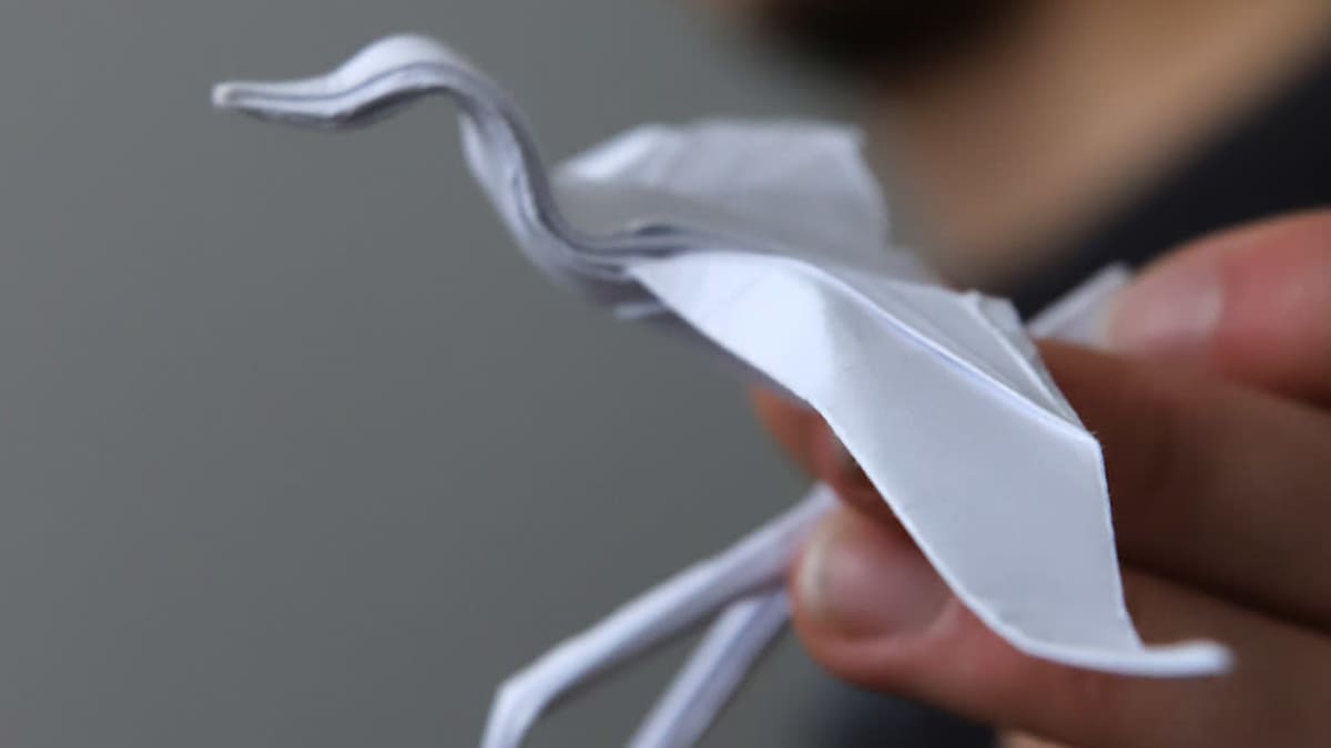 Juho Könkkölän kädessä origamikurki.