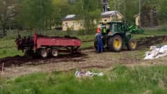 Tampereen viljelypalstoille levitetään kompostoitua hevosenlantaa. Hommissa traktori, kuski ja lannanlevityskärry. 
