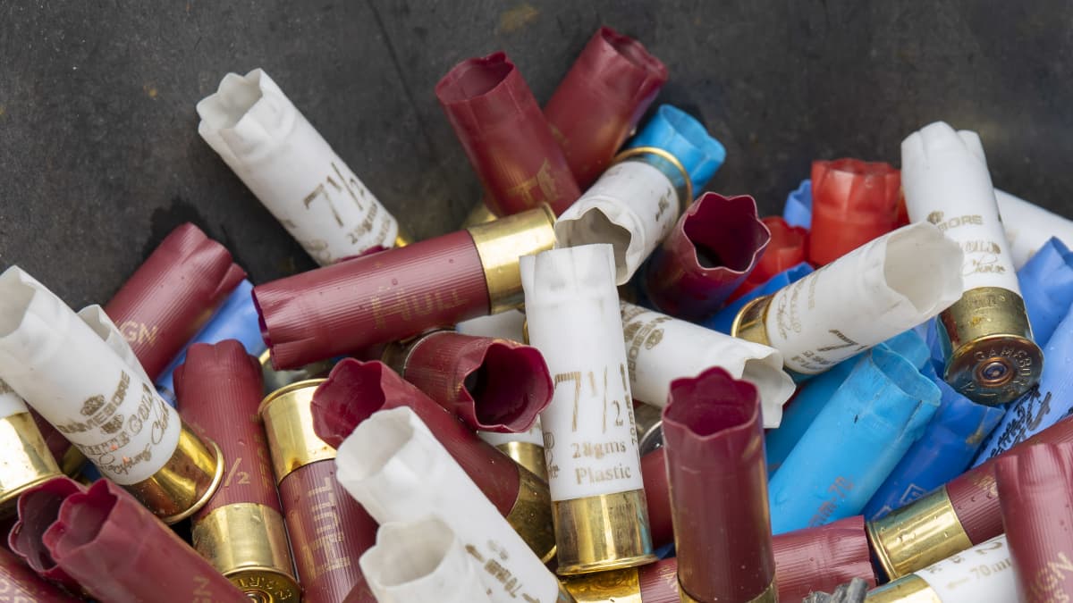 Käytettyjä haulikon patruunoita saavissa