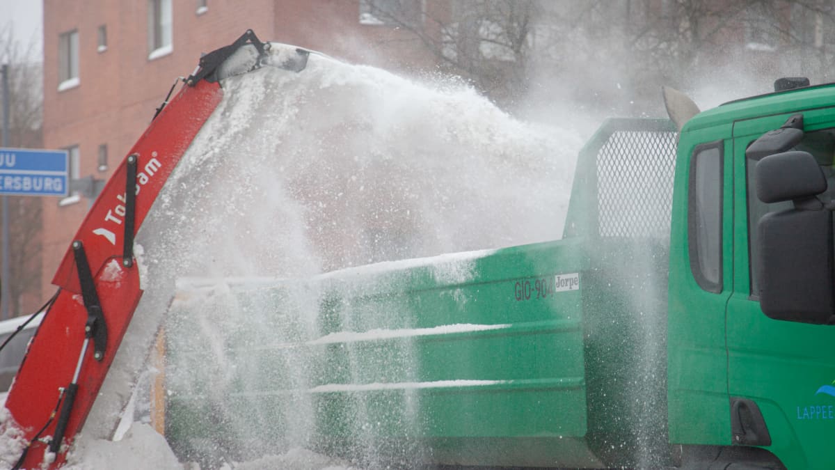 Traktoriin kiinnitetty lumilinko linkoaa lunta kadunvarresta kuorma-auton kyytiin Lappeenrannan keskustassa.