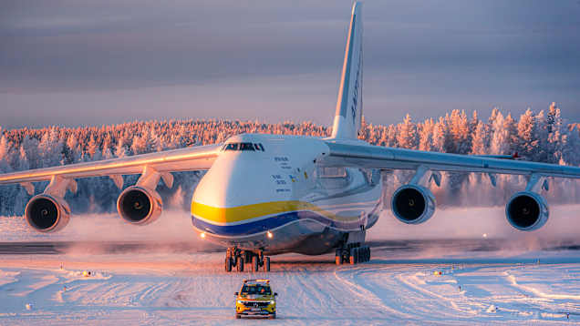 Iso Antonov -lentokone rullaa Rovaniemen lentoasemalla, etualalla Mercedes Benz -maasturi.