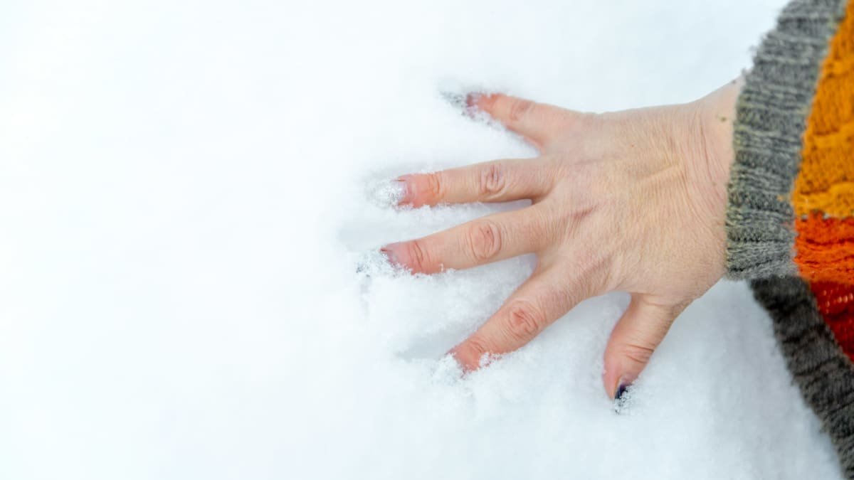 Jarna Pihlajamäki pitelee kättään lumessa.