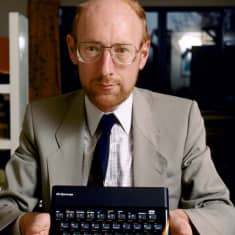 Clive Sinclair pitää kädessään Sinclair ZX Spectrum -mikrotietokonetta.