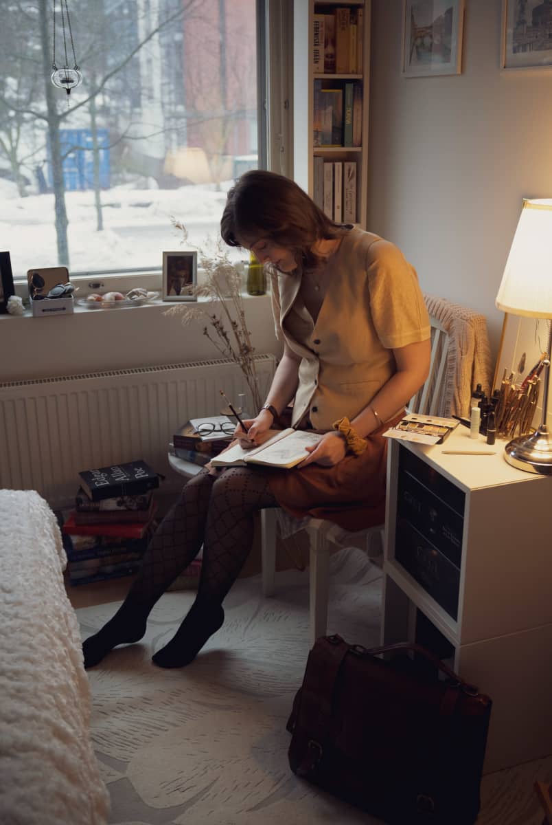 Dark academia-harrastaja Kajsa Roslund luonnostelee piirustusta makuuhuoneessaan.
