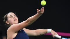 Anastasia Kulikova heittää tennispallon ilmaan ja katsoo sitä.