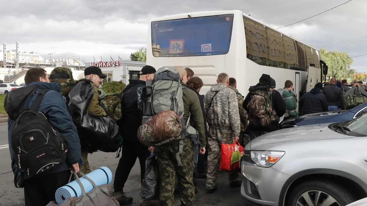 Venäläisiä armeijaan rekrytoituja nousee bussiin.