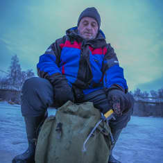 Kokkolalainen Armas Jansson istuu pilkkijakkarallaan jäällä ja pilkkii madetta.