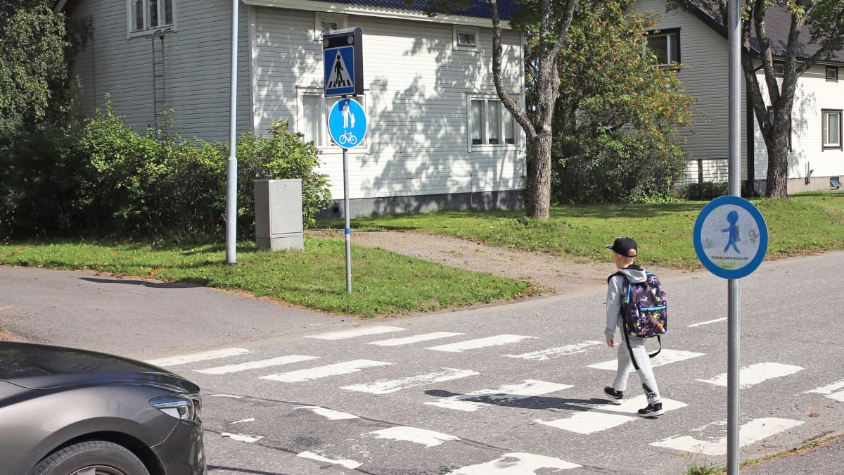 Koululainen ylittää tietä Harjun koulun lähettyvillä Pieksämäellä. Suojatiemerkissä vilkkuvalot.