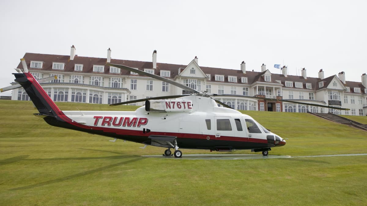 Helikopteri laskeutuneena lähelle hotellia. Kopterin kyljessä lukee Trump.